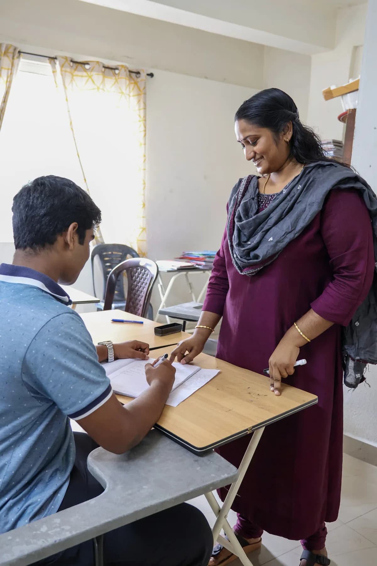 Tutor guiding a student at a desk